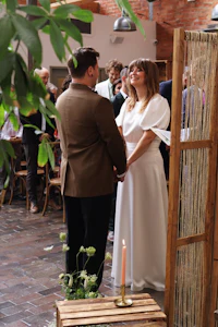 a bride and groom standing in front of a wooden frame
