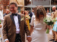 a bride and groom walk through confetti at their wedding