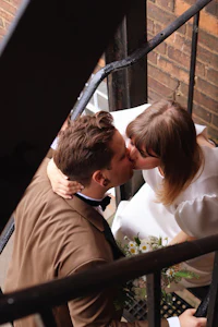 a bride and groom kissing on a staircase