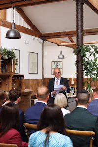a man in a suit giving a presentation to a group of people