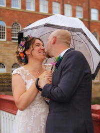 a bride and groom kissing under an umbrella