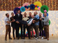 a group of men posing for a photo in front of a colorful backdrop