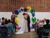 a bride and groom kiss in front of colorful paper lanterns