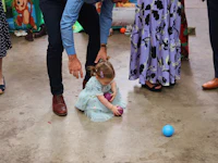 a little girl is playing with a ball
