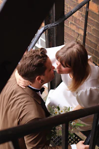 a bride and groom kissing on a staircase