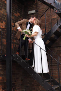 a bride and groom kissing on a staircase
