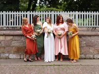 a group of bridesmaids standing in front of a stone wall